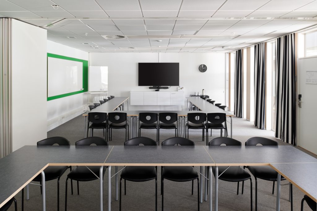Two conference rooms made into one with opened sliding walls. Chairs and tables in