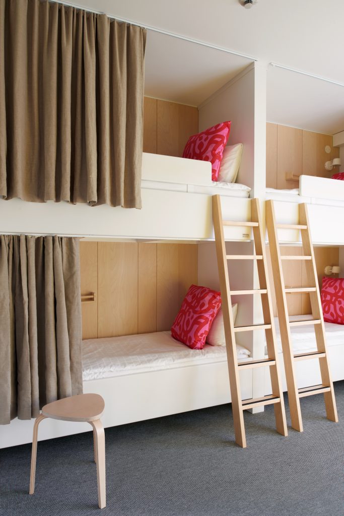 Två platsbyggda sängar med fördragna gardiner i ett familjerum.