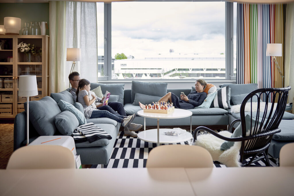Family together on living room sofa with view of IKEA Museum.